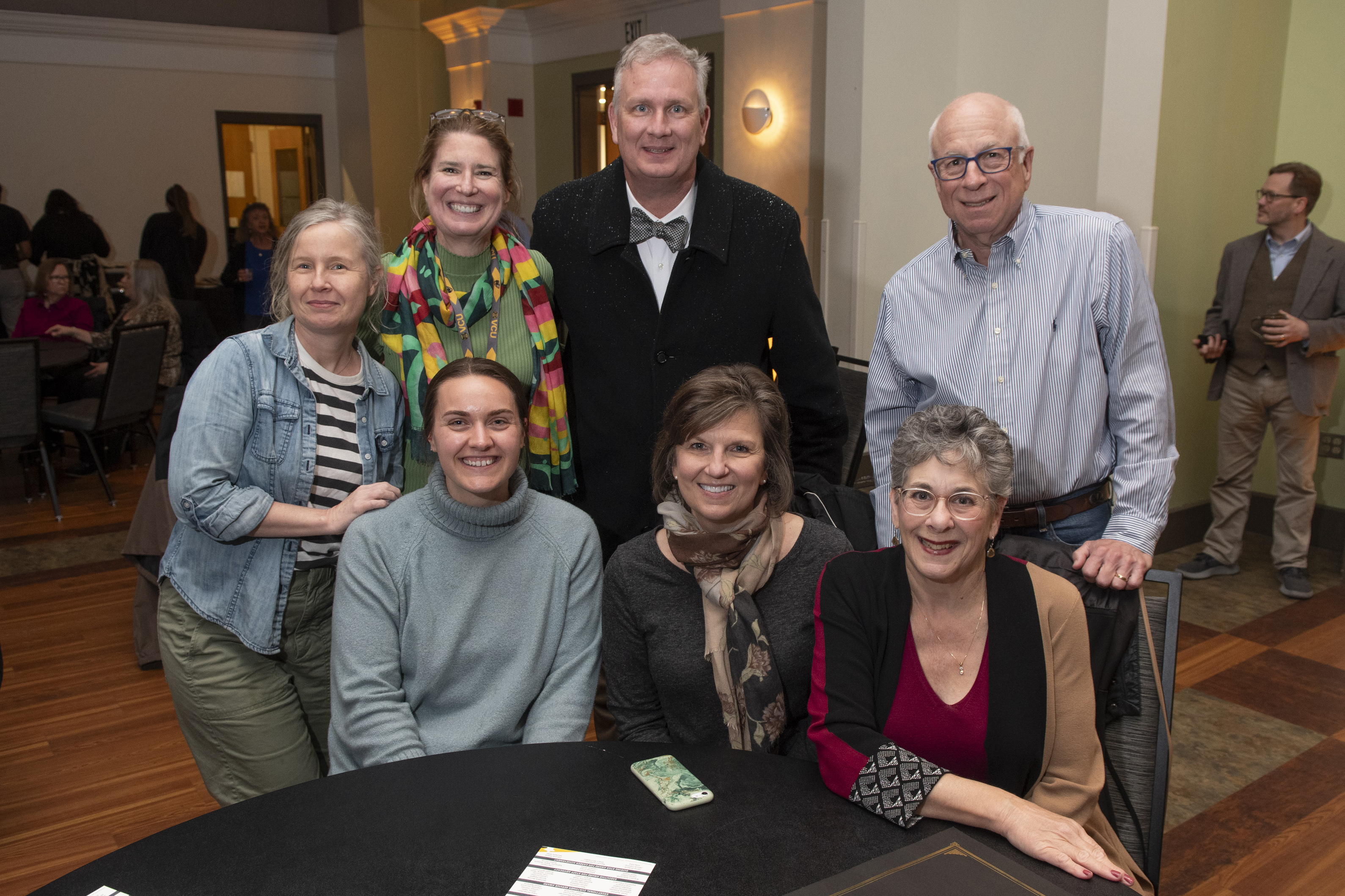 attendees standing and sitting around a table