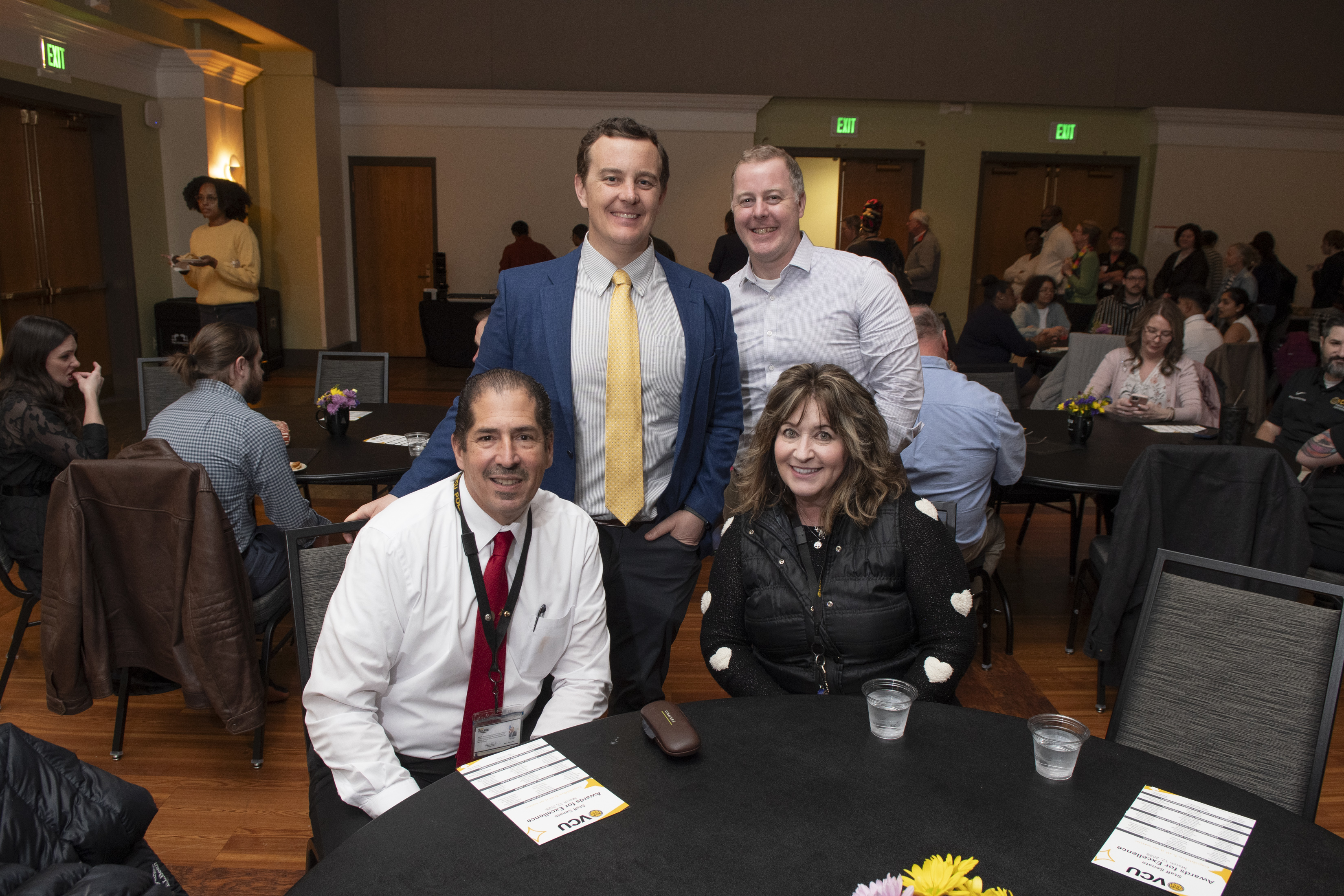 Attendees sitting and standing around a table